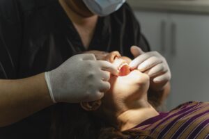 Patient consulting a periodontist about gingivitis symptoms in a dental office.